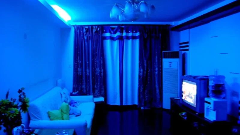 Sala de estar escura com televisão ligada em modo cinema